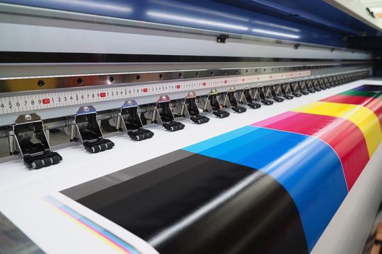 Printing press printing coloured paper.